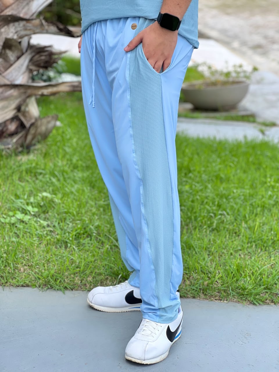 Detalhe da faixa lateral em tela perfurada da calça masculina azul claro — Jump Modas