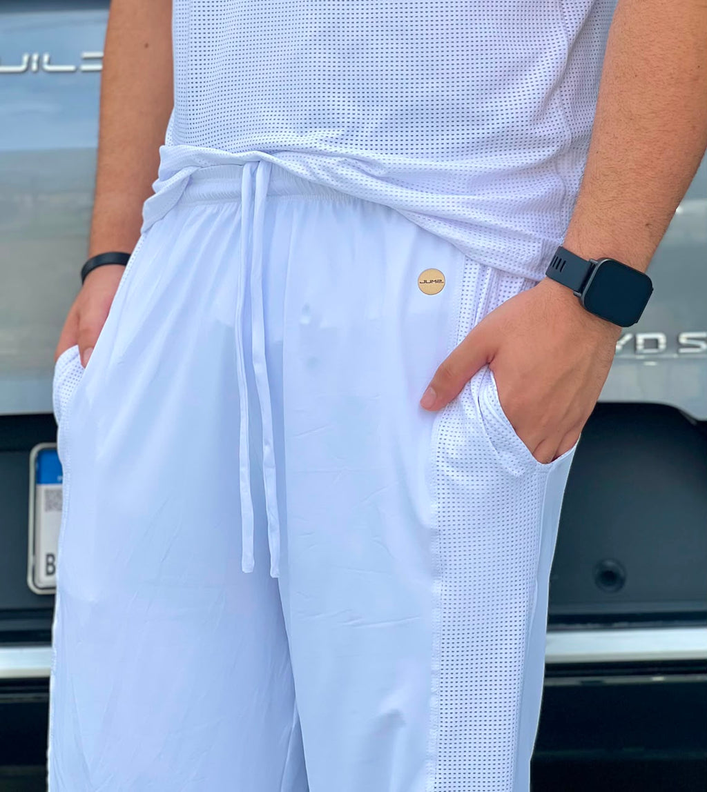 Detalhe do cós, cordão e selo dourado da calça masculina branca — Jump Modas