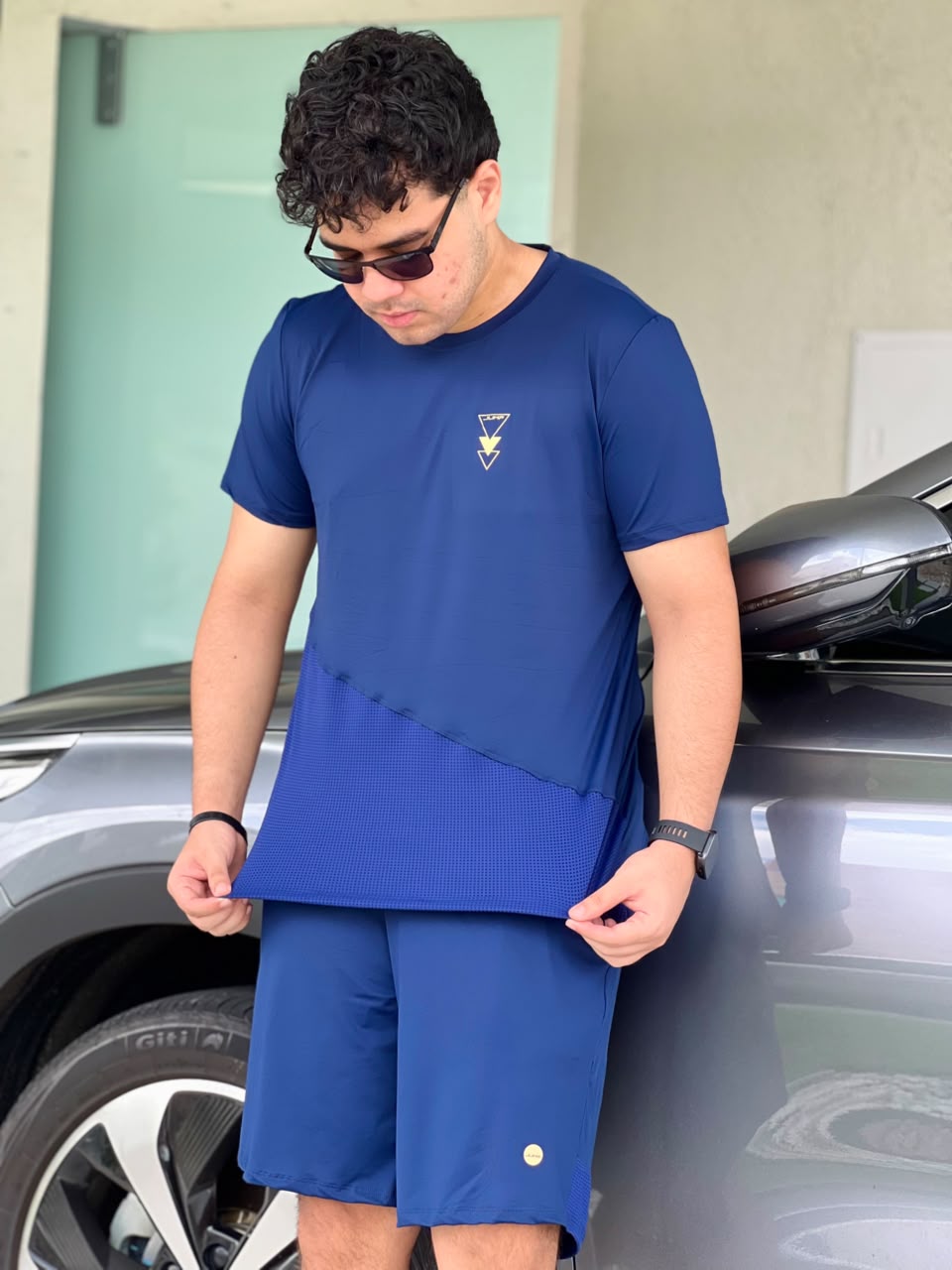 Detalhe do recorte diagonal e da barra em tela da camiseta azul marinho — Jump Modas