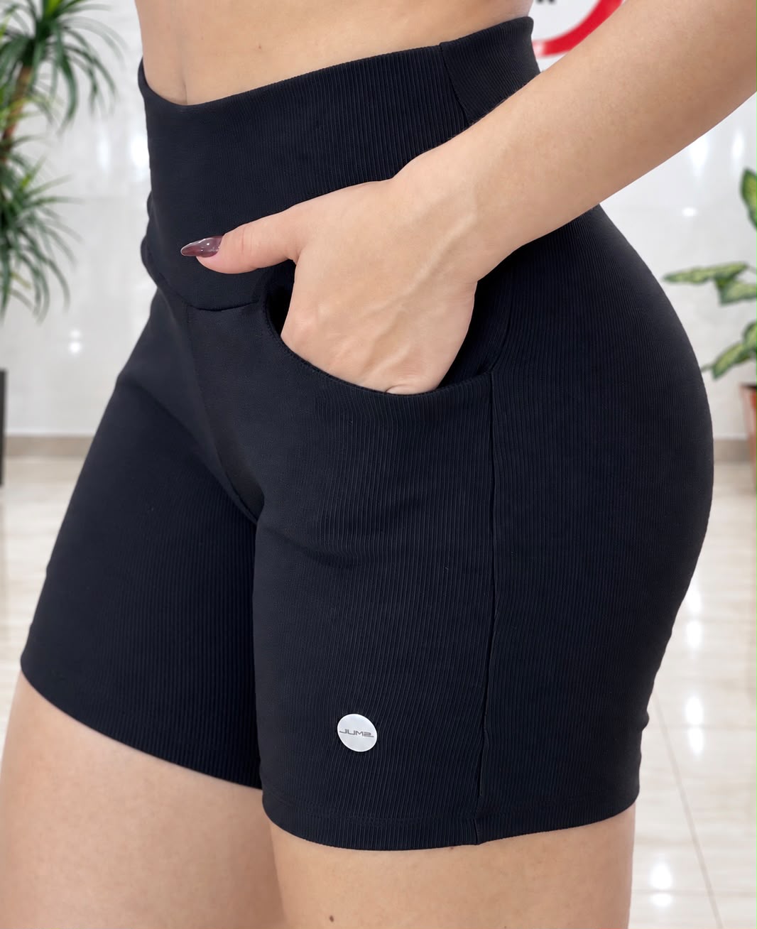 Detalhe do bolso lateral do short cintura alta canelado preto com bolso