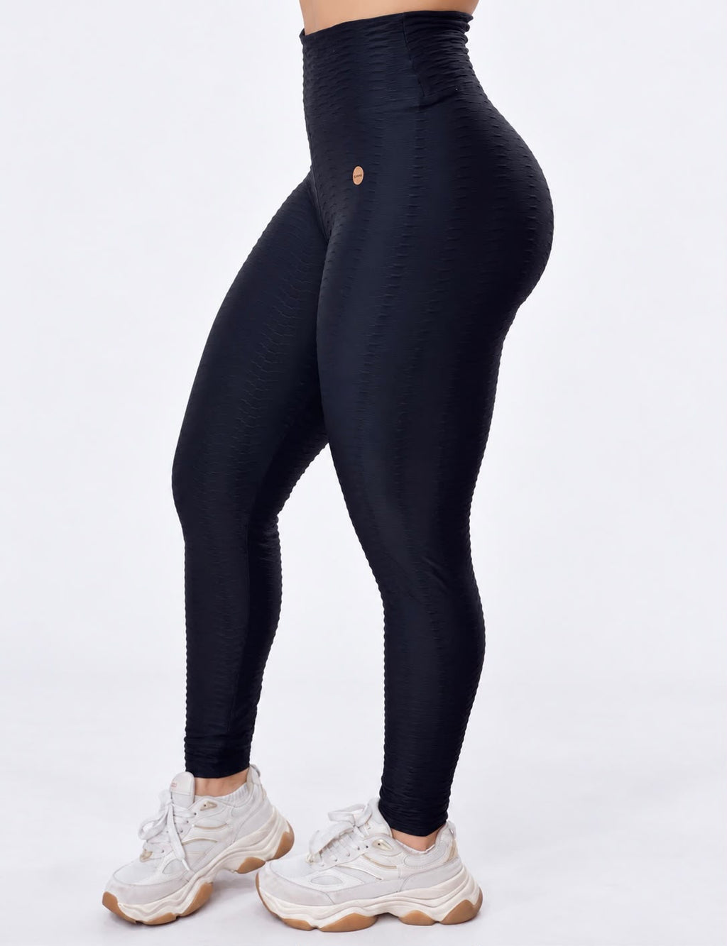 Detalhe do cós alto e do relevo em ondas da legging cintura alta preta texturizado 3d